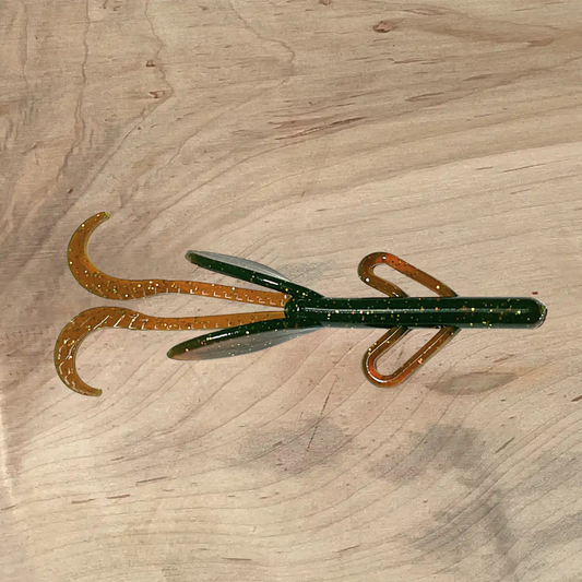Brush Beater morning coffee lure displayed on wood surface, showcasing its green and brown color with glittered details.